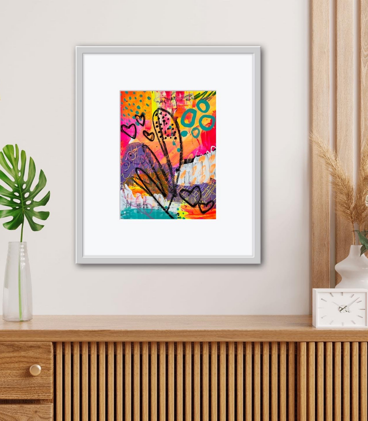 Shana Recker Art neon paint print framed in a white frame and hung on wall.